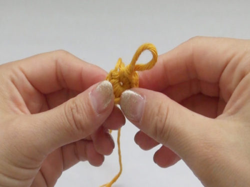 二重に巻いた糸始まりの糸を引っ張って、動いた方の糸を引っ張り、輪を引き締めます。